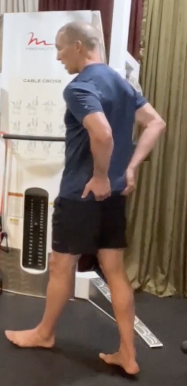 Walking test for glute activation, with fingertips on the glutes